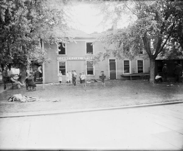 Exterior view of the Commercial Hotel, with men and children outside.