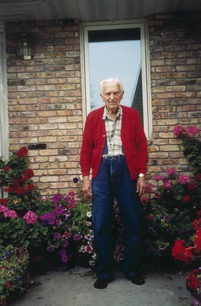 Portrait of Gordon Hampel standing amidst his flowers.