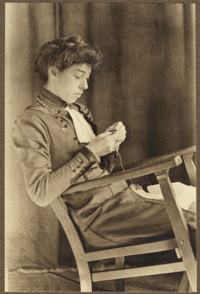 Portrait of Alice F. Jackson of Madison, sitting in a chair and crocheting.