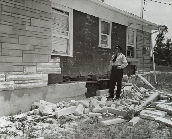 Police officer inspecting the damage to the home of Andrew Wade and his family after it was bombed.  