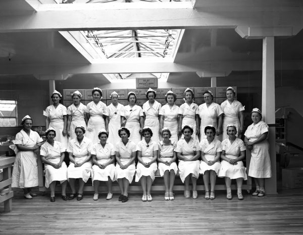 A group portrait of female workers at the Red Dot Potato Chip Company. Fourth from the left in the top row is Vivian Harrison Matheson, identified by Ellis Mason.