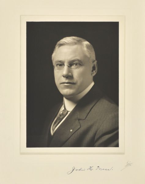 Quarter-length studio portrait of John H. Moss, Milwaukee company vice-president.
