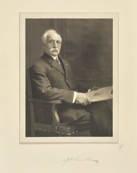Three-quarter length seated studio portrait of J.P. Rundle, Milwaukee company president.