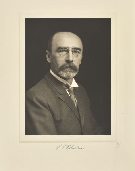 Quarter-length studio portrait of Louis F. Schecker, Milwaukee company president.