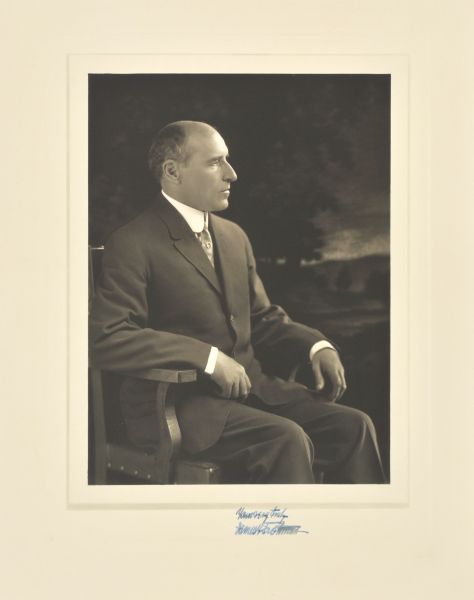 Three-quarter length seated side profile studio portrait in front of a painted backdrop of James F. Trottman, Milwaukee lawyer and manufacturer.