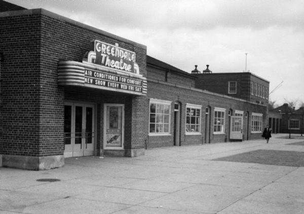 The front entrance of the Greendale Theater with other storefronts visible. The marquee reads "Greendale Theater, Air Conditioned For Comfort, New Show Every Wed Fri Sat." The theater was opened on April 29th, 1939.