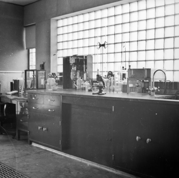 The interior of the sewage treatment plant laboratory. A microscope and many glass beakers are sitting on the counter.