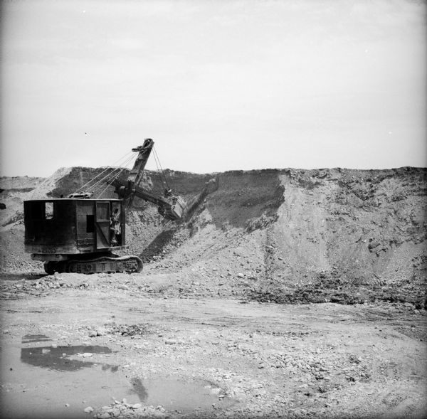 A steam shovel moving sand and gravel in a quarry.