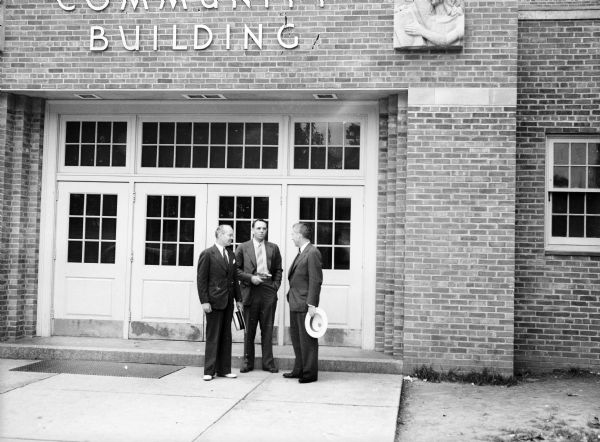 Henry Wallace, on right, talking to two men in front of the community center building. Henry Wallace, then the United States Secretary of Agriculture, visited and toured Greendale.