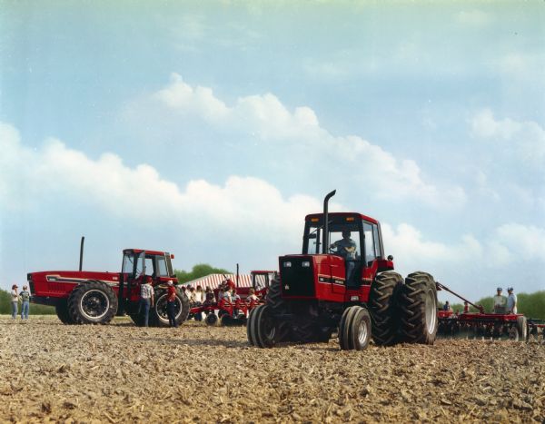 Color photograph of what may be a Red Power Days demonstration with a 5488 tractor and a 6588 tractor. Onlookers are standing in the background.