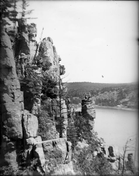 Elevated view of Cleopatra's Needle with Devil's Lake in the background. There is a cottage on the far side of the lake.