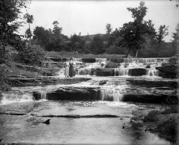 Two women stand on a ledge at Skillet Falls.