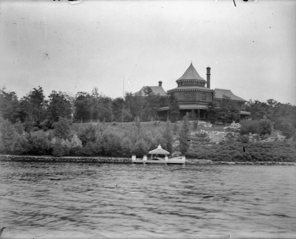 The Ceylon Building and its pier as seen from Lake Geneva. Originally built for the World's Columbian Exposition in Chicago, the building was later purchased by J.J. Mitchell, moved to Lake Geneva, and converted to a private residence. 
