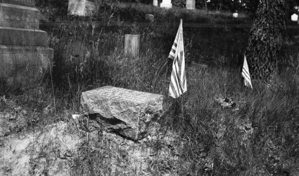 A small granite stone and American Flag mark the grave of Belle Boyd, actress and Confederate spy. The grave is inscribed with: "Belle Boyd, Confederate spy / Born in Virginia / Died in Wisconsin / Erected by a comrade."
