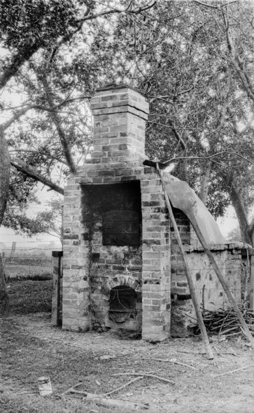 An outdoor brick bake oven with utensils alongside.  According to the photographer, these were "often used by the early taverns."