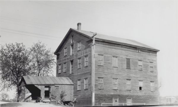 The three-story wooden mill building, built about 1848 by Snow and Walden. The building has twelve over twelve windows and an addition on the left.