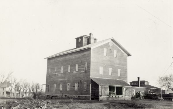 Large wooden mill building. This mill was built in 1872 by Benjamin Boorman on the site of an earlier (1842) mill built by McNeil, Elmore, and McClure. There is a house in the background on the left.