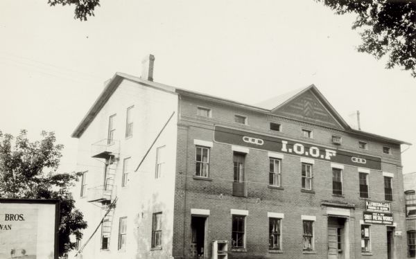This old hotel was known variously as the Park, Brick, or Circus hotel and dates from the 1870s. The large brick structure has a front gable with fancy shingle work. At the time of this photograph, the building housed the Oddfellows hall, Freitag plumbing and Fey and Fey sheet metal works; it later became a Chevrolet dealership.