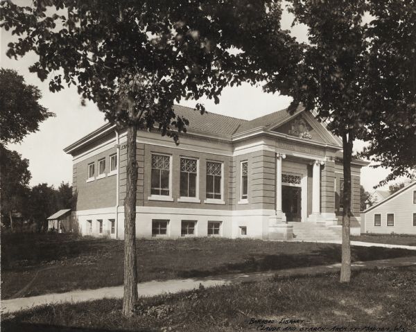 Exterior view of the Baraboo Carnegie Free Library. The library opened in 1903 and Andrew Carnegie donated $15,000. Above the main entrance it reads: "Carnegie Free Library." At the bottom of the photograph it reads: "Baraboo Library - Claude and Starck - Arch'ts - Madison, Wis."