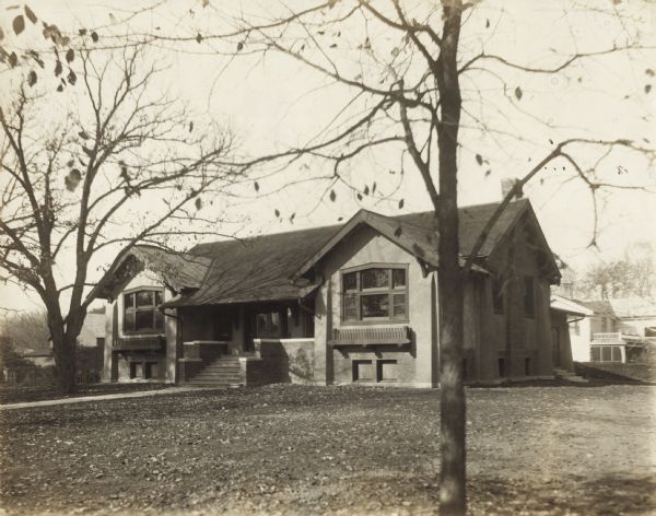 Exterior view of the Columbus Library. Reverse of mounting reads: "1912, Carnegie bldg. $ Cost 10,000 - Claude + Starck, Madison, arch." Brick and Stucco craftsman bungalow style building.<p>Additional notes from "New Types of Small Library Buildings, 1913." COST - Contract, 9,960. Lighting, fixtures, etc., $259. Furniture and other equipment, $510.12. CONSTRUCTION - Bungalow type designed to give the effect of a reading club rather than a more formal design. Concrete foundation. Superstruction hollow tile with rough cast cement finish; stained cypress woodwork; shingle roof; plate glass; oak finish; indirect lighting; steam heat. DIMENSIONS - 63'X26'. CAPACITY - About 7,000 volumes with future slack capacity of 9,500. Floor plans are included.</p>