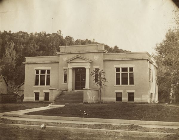 Exterior view of the Hudson Public Library. The library opened in 1904 and was funded by Andrew Carnegie with a gift of $12,000. The word "Library" is above the main entrance. Corner stone of the building reads: "1903."