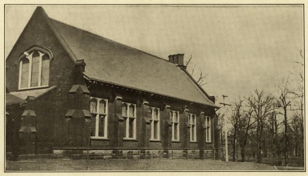 Exterior view of the Greene Memorial Library of Milwaukee-Downer College (now the University of Wisconsin-Milwaukee). The image is part of a 14-page pamphlet created by Hammersmith Engraving Co., Milwaukee, to advertise Downer College. Side view of brick building, with arched windows, and gothic buttressing.