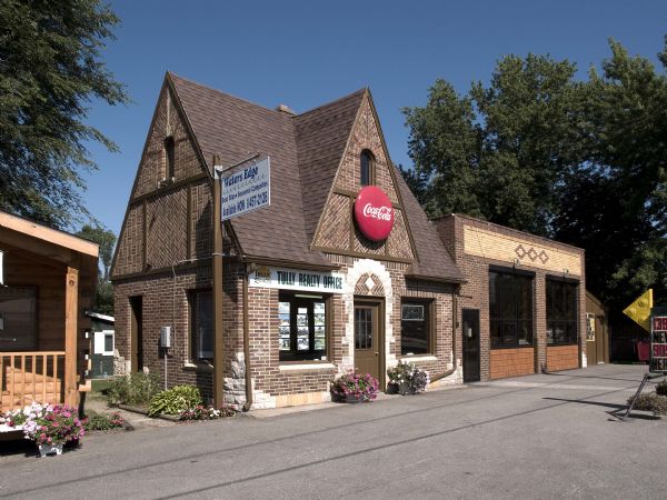 In 1933, Lester Proksch constructed this striking filling station in the small river town, at 201 North Main Street. Less's Service was opened in July of 1933.