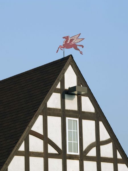 A red and winged horse weather vane sits atop the Mobil station.