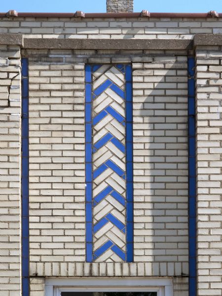 Constructed of a cream-colored brick, the vertical lines were embellished with blue glazed brick, likely meant to match the color of the Dixie Oil and Gasoline product line the station carried.