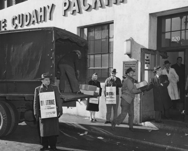 On the first day of their strike against the Cudahy Company, picketing workers in New York City permit the loading of cartons of ham and bacon for city hospitals.