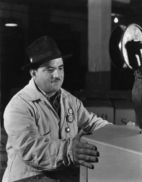 An unidentified United Packinghouse of America member. He is wearing badges that identify him as an employee at the Swift Company plant in Chicago and the steward of the local.