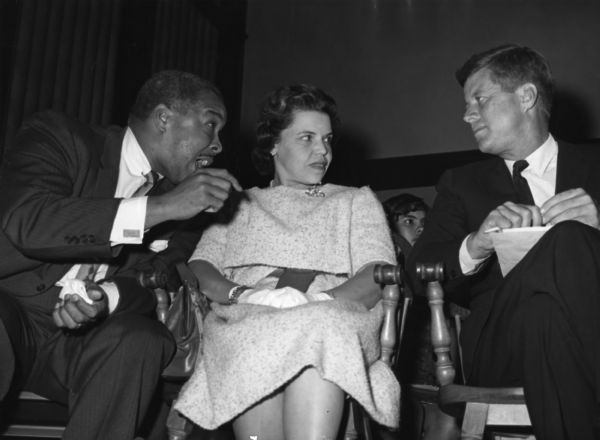 Senator John F. Kennedy, then campaigning for the presidency, speaks with Frank D. Reeves and Marjorie Lawson during a meeting of the American Council on Human Relations at Howard University. Although Richard Nixon was invited he turned down the invitation to speak to the conference.