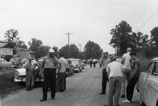 Photograph taken by a member of striking UPWA (United Packinghouse Workers of America) Local 680 of a strike against the R.L. Zeigler Company. It shows the close police surveillance of the picketers' activities.