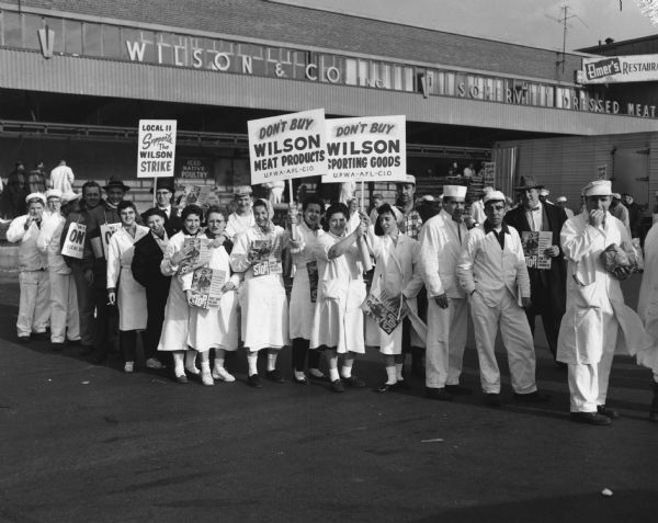 Picket line of United Packinghouse Workers of America (UPWA) Local 11 in front of the plant of the Wilson meatpacking company. Although unidentified except for the internal information, the photograph probably represents the national 1959 "Don't Buy Wilson" campaign.