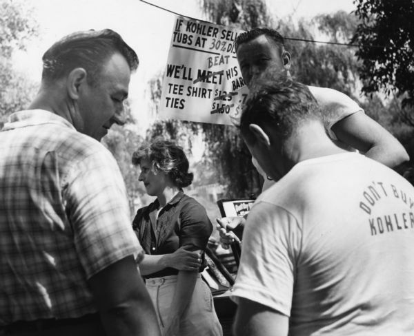 Unidentified photograph from the archives of the United Packinghouse Workers of America showing the boycott of Kohler Company products. The strike by the Kohler workers begun in 1954 was one of the longest strikes in the nation's history. One man is wearing a t-shirt that says: "Don't Buy Kohler."