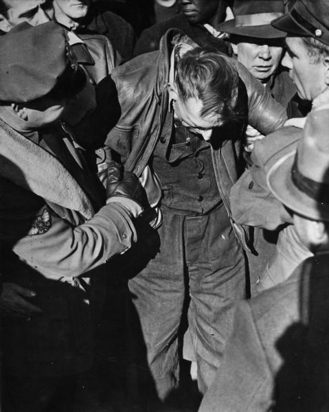 Elevated view of a Swift Company striker being taken from the CIO picket line by police. The striker was reported to have been beaten and arrested.