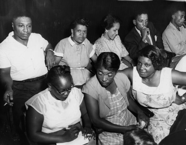 A group of African Americans in the courtroom at the Emmett Till murder trial. The 14-year-old Till, who was visiting Mississippi from Chicago, was murdered by two white men for allegedly whistling at a white woman. The defendants were acquitted, although they later confessed to the crime. The woman in the front row who is taking notes has been identified as Lillian Pittman, who was a member of a United Packinghouse Workers of American in Mississippi. Her notes were meant to inform the coverage of journalists who were not admitted to the courtroom.