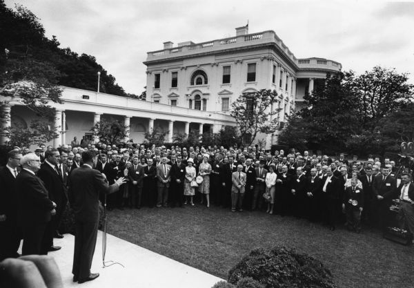 President John F. Kennedy meeting with delegates to the Amalgamated Meat Cutter and Butcher Workers Union in the White House rose garden.  The labor leaders were in town for a legislative and COPE conference.  Patrick Gorman, president of the union, stands behind Kennedy.