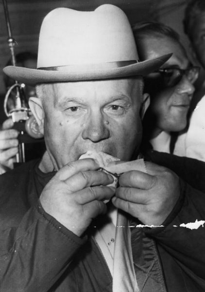 Interviewed outside a meat packing plant near Des Moines, Russian Premier Nikita Khrushchev pronounced his first American hot dog to be "wonderful, but not enough." The caption reported that although he was told the packing plant had plenty more, he declined to eat a second.