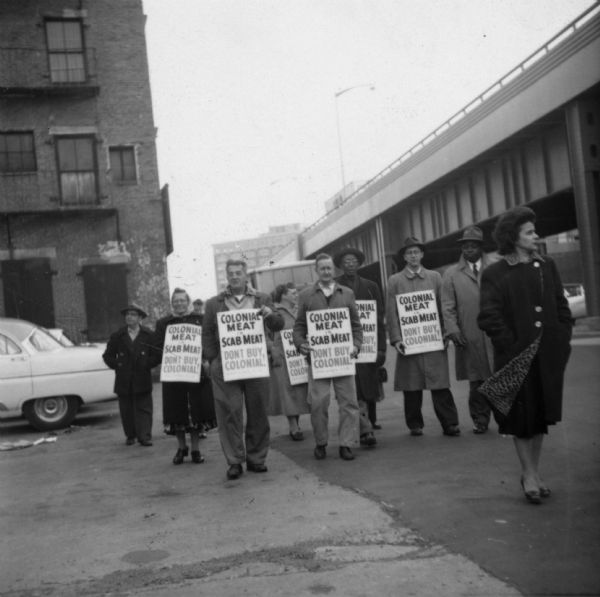 United Packinghouse Workers of America picketers protest the hiring of temporary scab labor by the Colonial Provisions Company. Although no location or dated is noted on the original photograph, it is thought that it represents the 1954-1955 strike of UPWA Local 11, one of the longest strikes in Boston history.