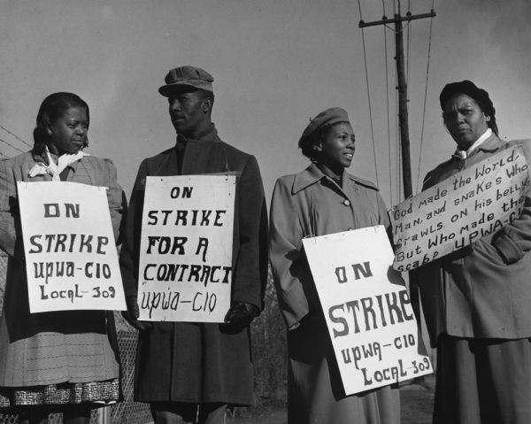 Four members of United Packinghouse Workers Union Local 309 (which was part of District 9) on strike against the W.W. Pickle Company. The picket sign carried by one woman, Lucille Lewis, expresses the antipathy strikers felt toward the workers who crossed their picket lines. Her sign reads: "God made the world, man, and snakes who crawls on his belly. But who made the Scab?"  The other strikers (left to right) are Janie B. Harris, Arthur Germany, and Hattie Matthews.