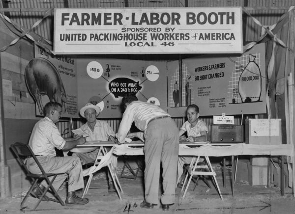 Booth sponsored by United Packinghouse Workers Union Local 46 at the Black Hawk County Fair. The booth included a special exhibit that illustrated how both the farmer and the worker were short changed by the American market. The booth was part of a concerted outreach by the UPWA throughout the Midwest to demonstrate the need for farmer-labor solidarity.