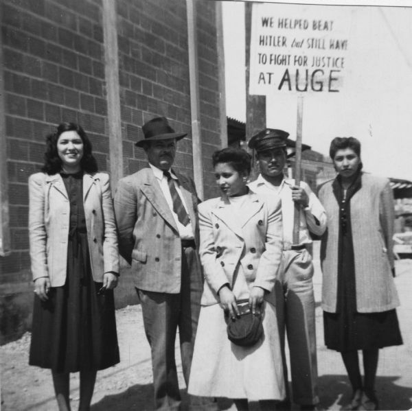 Four Texas workers with a picket sign that uses their wartime service and sacrifices to negotiate for a union contract.