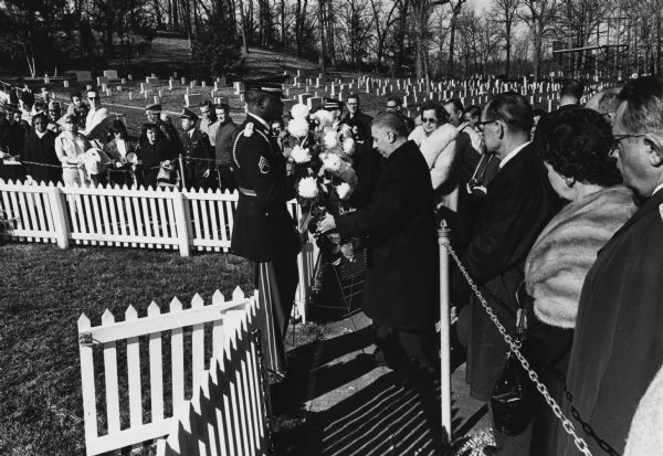 Delegates from the International Labor Press Association place a marker on the grave of President John F. Kennedy to mark the first anniversary of his death.