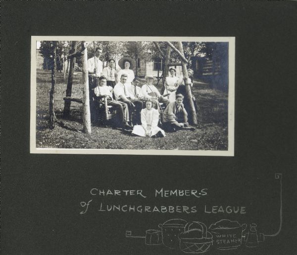 A group of individuals sit on a log lawn swing in the yard of the Drew cottage. Features a caption that reads, "Charter members of lunchgrabbers league." Hand-drawn picnic foods are also featured. Individuals are identified as: far left on swing, Frank O. King; far right on swing, Frank Drew, sitting, with hat and walking stick; standing behind swing, far right, Delia Drew King; sitting on ground, left, Doris Drew; sitting on right swing frame, second from right, Lillian Drew.