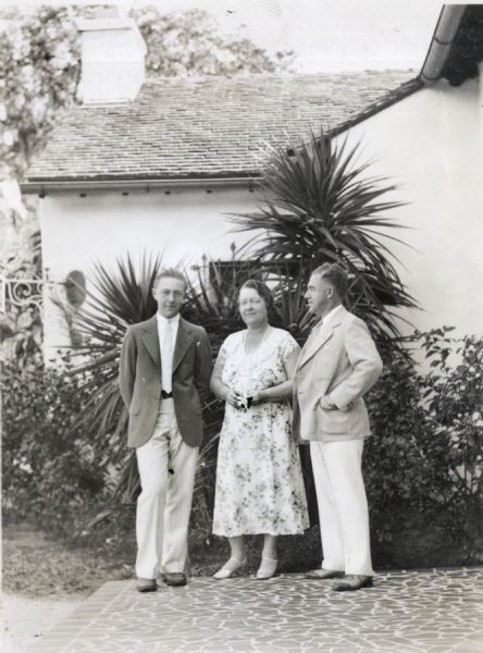 Members of the King family posing outdoors near a house. From left to right: Robert Drew King, son; Delia Drew King, mother; Frank O. King, father.