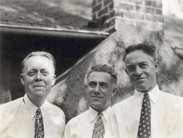 Close-up portrait of three men standing outdoors near a house. From left to right: Walter White Drew, Frank O. King, and Bill Gannon. Walter White Drew was the inspiration for "Uncle Walt" and Bill Gannon the inspiration for "Bill," both characters in King's <i>Gasoline Alley</i> cartoon.