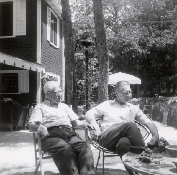 Frank O. King and Robert Drew King relax outdoors in chairs at the Lake Flora Bell vacation home.
