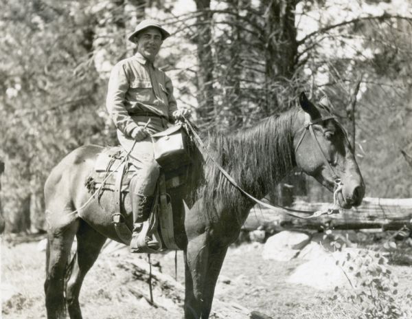 Frank O. King poses for a photograph while riding horseback in the American Southwest. In 1923, Frank and Delia traveled to the Grand Canyon, Monument Valley and Rainbow Bridge Monument.