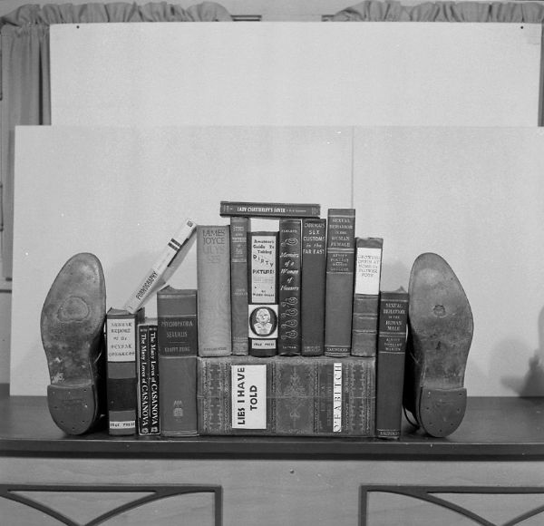 "Shoe" bookends holding together a group of books with humorous fiction titles.